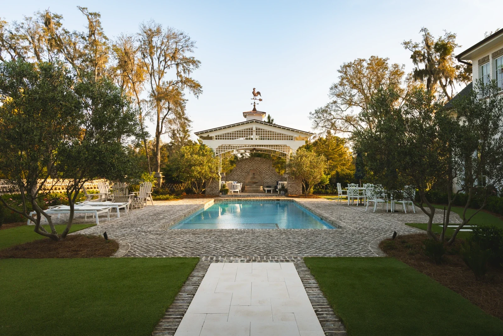 Pool, lawn and garden pavilion framed by mature coastal planting